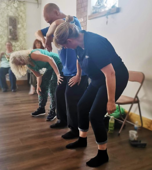 Students following a gentle folding movement in a workshop